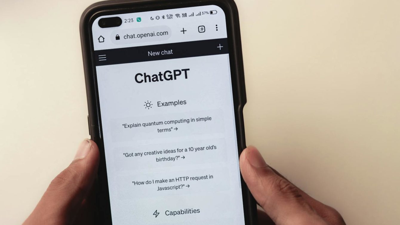 Close-up of hands holding a smartphone displaying the ChatGPT application interface on the screen.