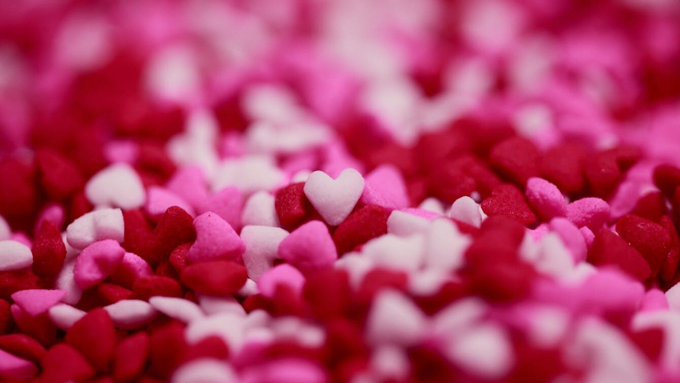 Close-up of pink and red heart-shaped candy sprinkles, perfect for Valentine's Day themes.