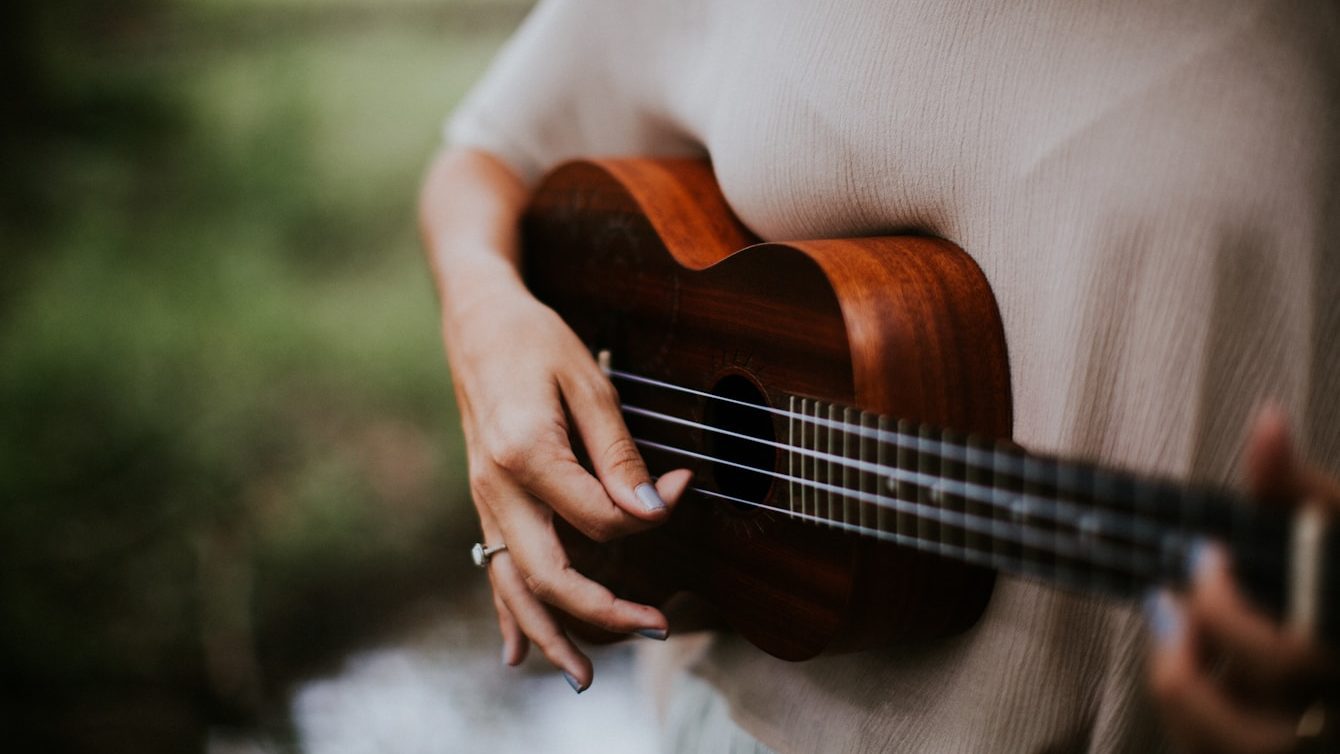 woman playing ukulele at daytime